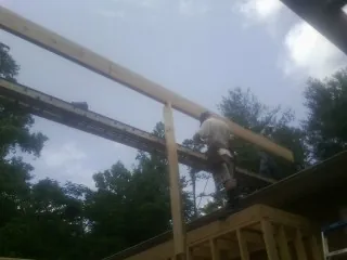 Carpenter setting a ridge beam over a new addition frame — Ice Dam Removal by Roofing Brothers in Baraboo