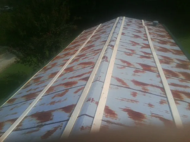 Rusted metal roof panels with new wood purlins before replacement — Storm Damage Roof Repair in Baraboo by Roofing Brothers
