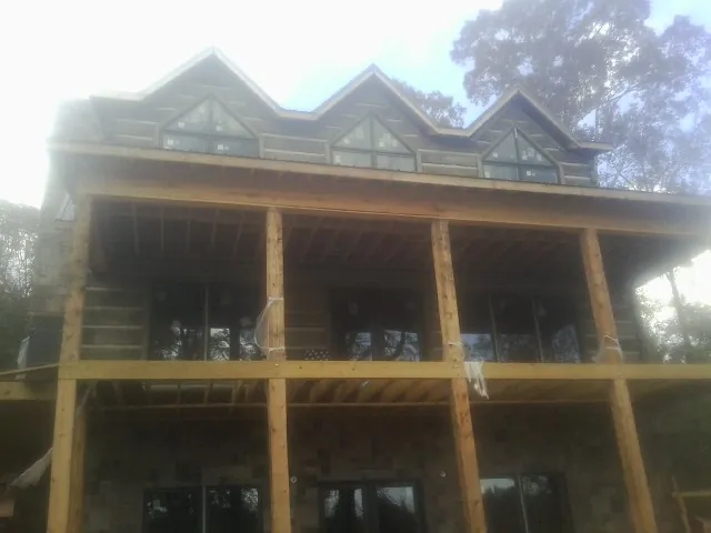 Dormers and porch framing on a large log home under construction — Roof Coating work by our crew in Baraboo