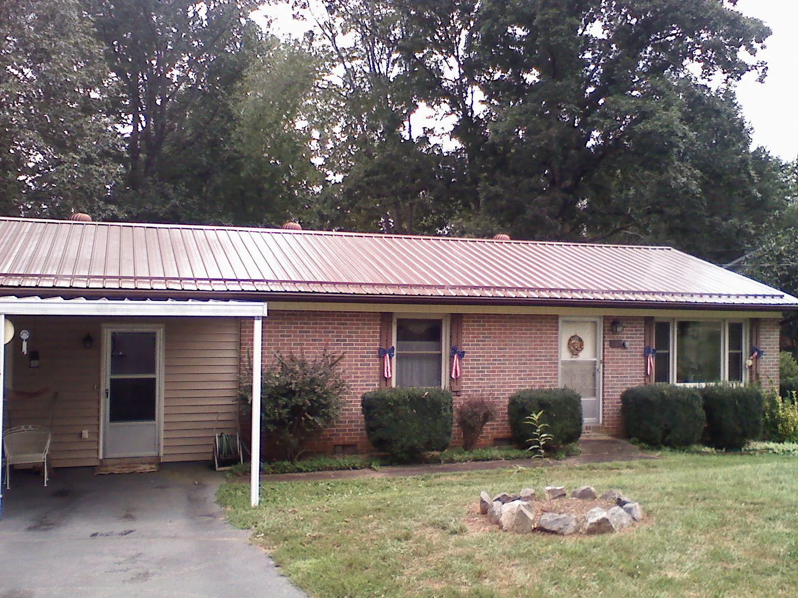 Bronze metal roof and carport on a brick ranch home — Roof Repair work by our crew in Baraboo