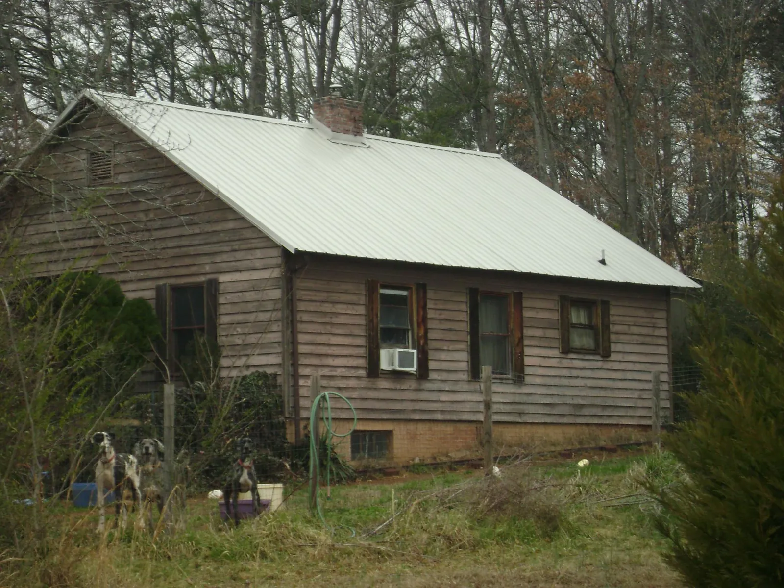 White metal roof on an old wood sided farmhouse, from a Metal Roof Installation job in Baraboo